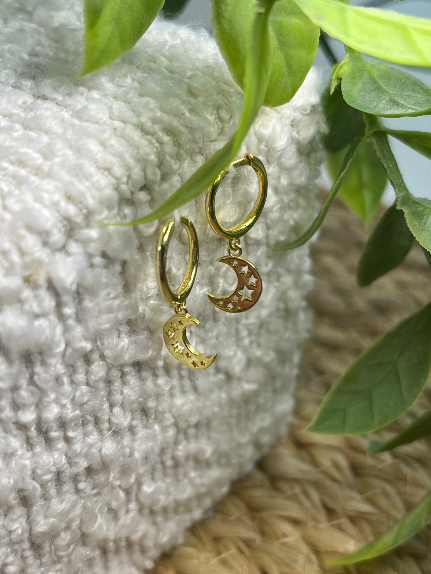 Gold plated hoop earrings feature crescent moon charms with star cut-outs