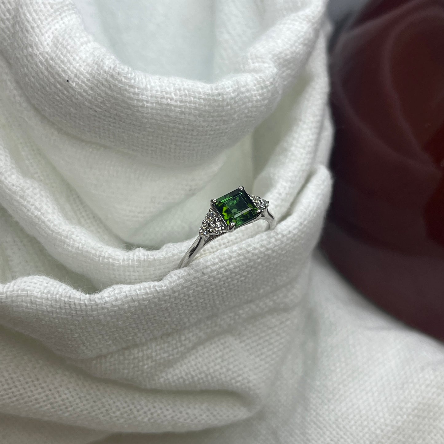 Step cut Teal tourmaline ring with trefoil diamond setting on shoulders