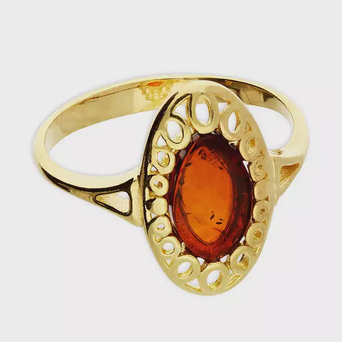 Gold-plated cognac amber oval set in a fancy oval surround